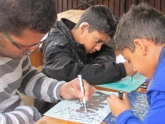 Boys doing graffiti style drawing on paper