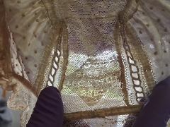 Bonnet being held up to light so writing can be seen