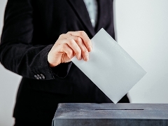 ballot box hand putting ballot paper in box