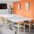 a meeting room with orange wall and a table and 12 seats set up for a meeting