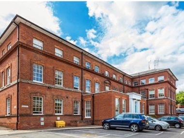 exterior photo of old millmead house with blue sky and cars parked out the front.