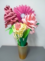 a vase filled with flowers made from coloured paper