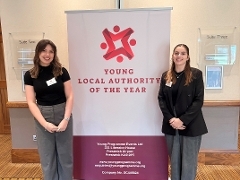 Two women, with brown hair with a sign saying Young Local Authority of the Year Awards, 