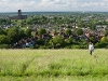 View of woman walking dog on hills above view of Guildford and the cathedral on the skyline